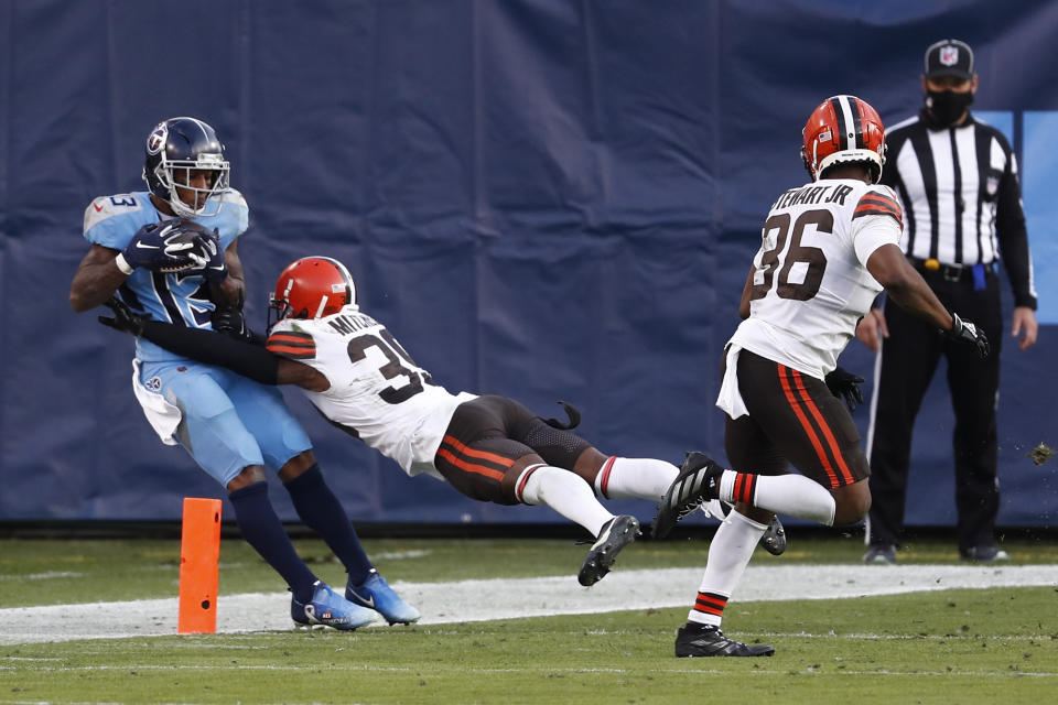 Tennessee Titans wide receiver Cameron Batson (13) catches a touchdown pass as he is hit by Cleveland Browns cornerback Terrance Mitchell (39) in the second half of an NFL football game Sunday, Dec. 6, 2020, in Nashville, Tenn. (AP Photo/Wade Payne)