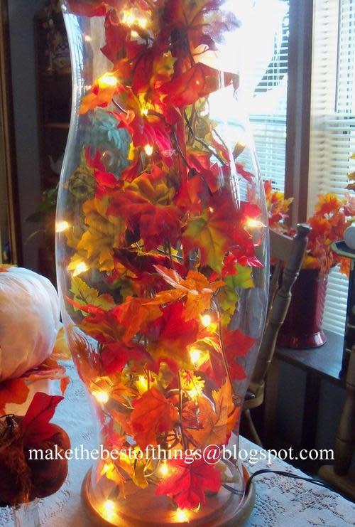 leaves and christmas lights put in to a hurricane jar