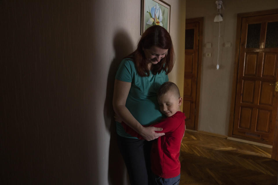 Marta, 38-weeks pregnant, holds her 6-year-old son Nazar, at an apartment given to them by a cousin after fleeing their home in Kyiv, in Lviv, western Ukraine, Sunday, April 3, 2022. The place in Kyiv where Marta was meant to give birth was bombed. Her birth plan, like almost everything else, was left behind. (AP Photo/Nariman El-Mofty)