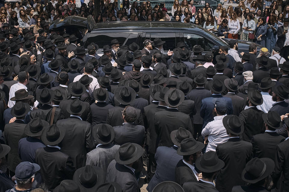 People walk and touch the coffin during the funeral procession of Rabbi Moshe Kotlarsky, Vice Chairman of Merkos L'Inyonei Chinuch—the educational arm of the Chabad-Lubavitch movement—and Director of the annual International Conference of Chabad-Lubavitch Emissaries on Wednesday, June 5, 2024, in the Brooklyn borough of New York. Rabbi Moshe passed away on Tuesday, June 4th, 2024. He was only four days shy of his 75th birthday. (AP Photo/Andres Kudacki)