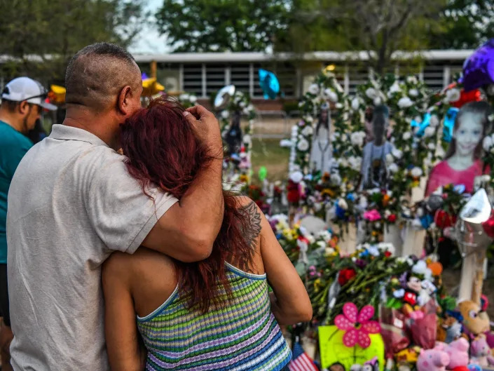 People pay tribute and mourn at a makeshift memorial for the victims of the Robb Elementary School shooting in Uvalde, Texas, May 31, 2022.