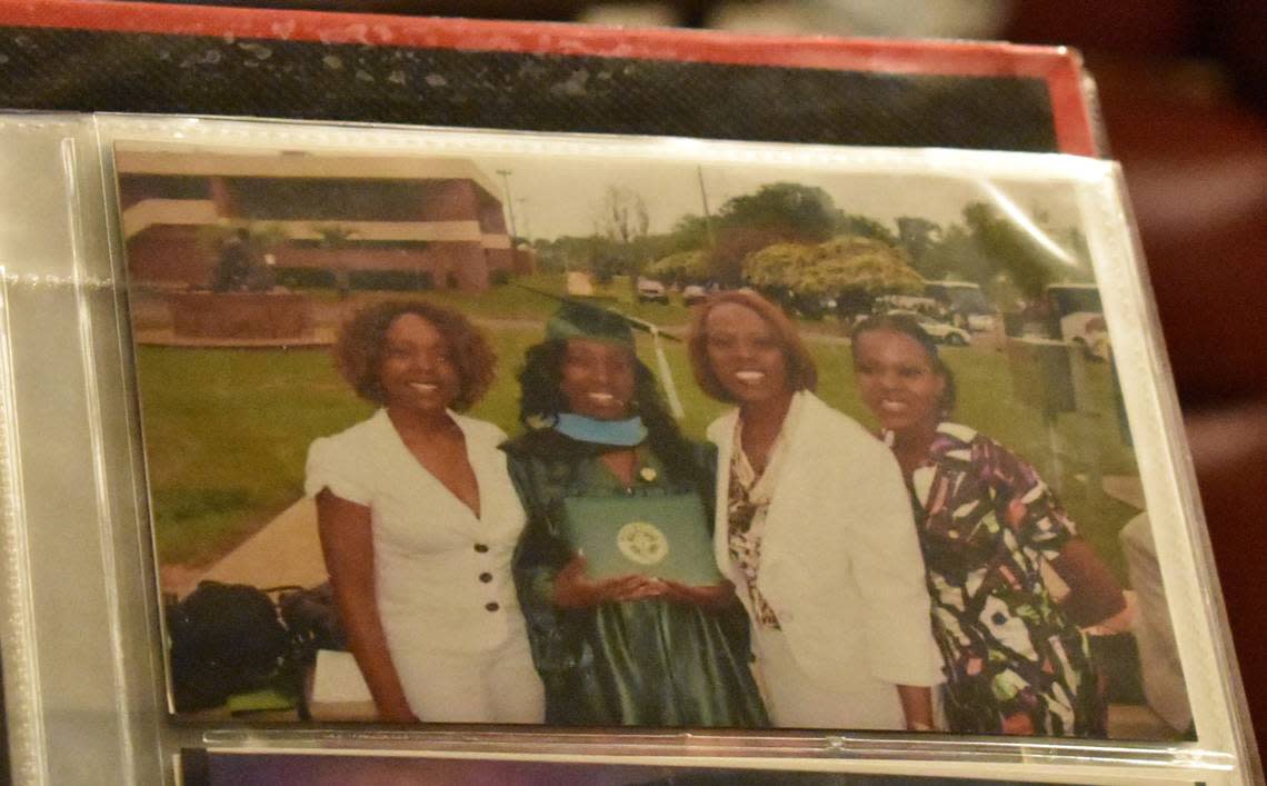Raghan Pickett shows a family photo of Ebony Pickett, 48, Keri Miller, 35, Evelyn Wrispus-Williams, 70, and Benea Denson, 38, at Miller’s graduation. All of these women attended Florida Agricultural and Mechanical University, and Pickett, Miller, and Denson were awarded the Rosewood scholarship. (Fresh Take Florida/Lauren Whiddon)