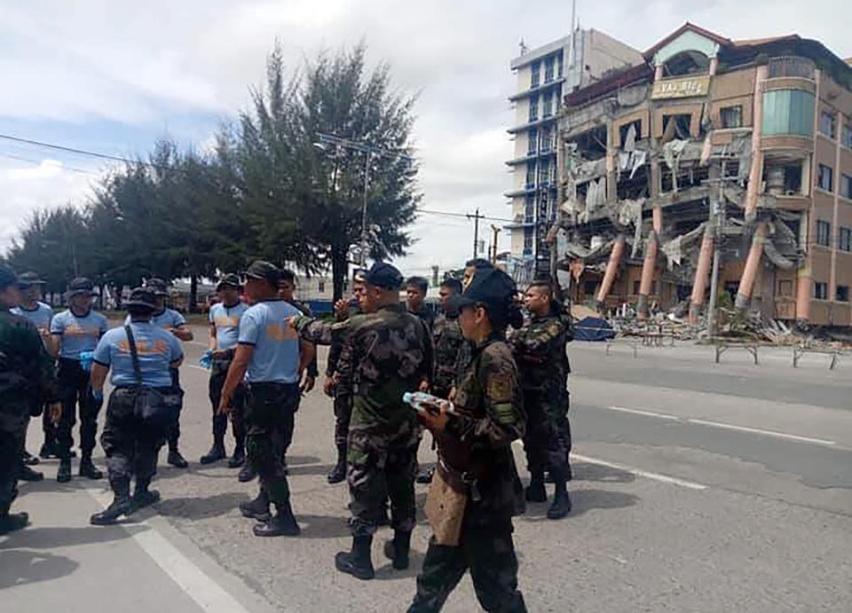 Police secure the area near Eva's Hotel, right, damaged after a strong earthquake in Kidapawan, north Cotabato province, Philippines, Thursday, Oct. 31, 2019. The third strong earthquake this month jolted the southern Philippines on Thursday morning, further damaging structures already weakened by the earlier shaking. (AP Photos/Williamor Magbanua)