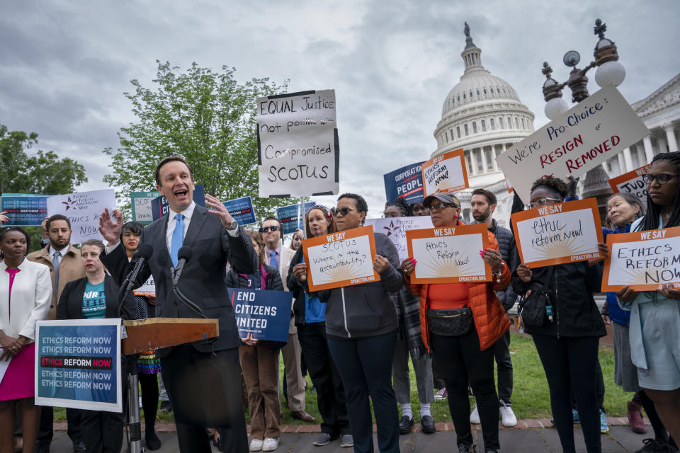 FILE - Sen. Chris Murphy, D-Conn., left, joins activists in their call for ethics reform in the U.S. Supreme Court, at the Capitol in Washington, Tuesday, May 2, 2023. (AP Photo/J. Scott Applewhite, File)