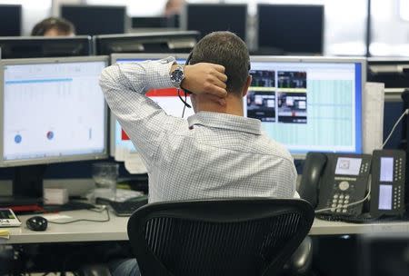 A trader sits at his desk at IG Index in London September 9, 2014. REUTERS/Luke MacGregor