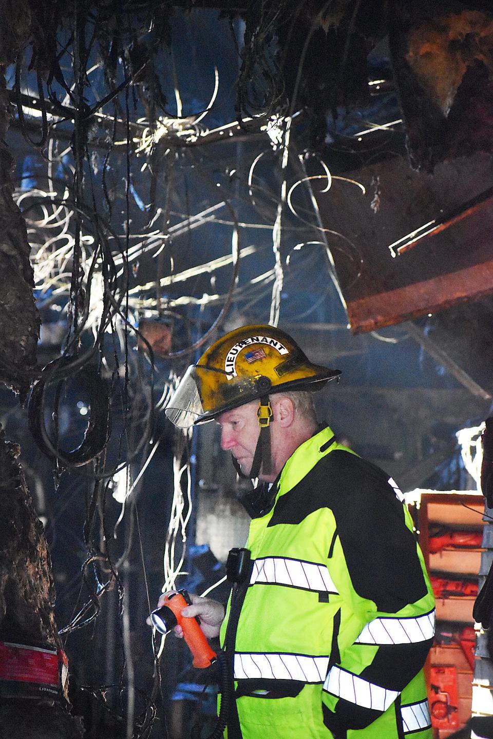A firefighter inspects the damage at Burns Power Tools in Fall River on Tuesday.