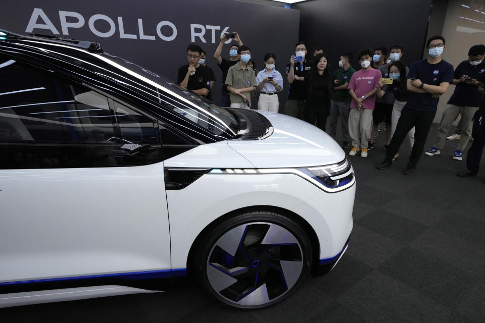 Journalists attend a preview of the Apollo RT6, a fully electric vehicle with an "optional" steering wheel that can be removed or installed when required, Wednesday, July 20, 2022, in Beijing. Chinese search engine and artificial intelligence firm Baidu on Thursday, July 21 unveiled its latest electric autonomous driving vehicle that it says will be soon be part of its robotaxi fleet, as China pushes forward with its autonomous driving ambitions. (AP Photo/Ng Han Guan)
