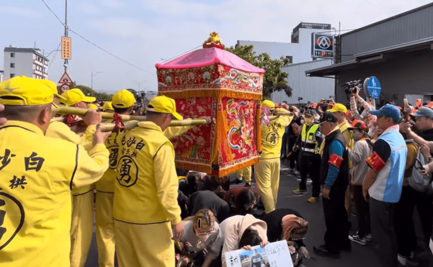 家屬祈求早日找到失蹤弟弟，白沙屯媽祖讓劉男家屬鑽過轎底。（翻攝自白沙屯媽祖網路電視台YouTube）