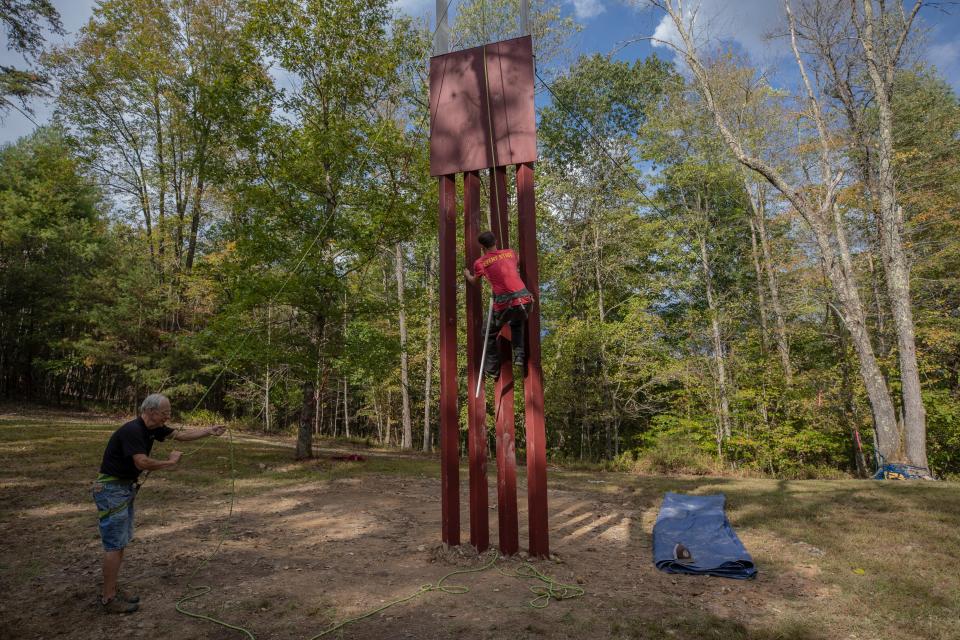 Kentucky climbing guide and Muir Valley property manager Erik Kloeker, right, ascends a replica of President Donald Trump's new border wall design at the Muir Valley climbing area as founder Rick Weber looks on.