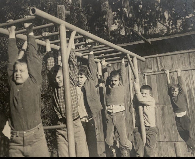 Boys climb along the bars at the Tiger Athletic Club, circa 1950s.
