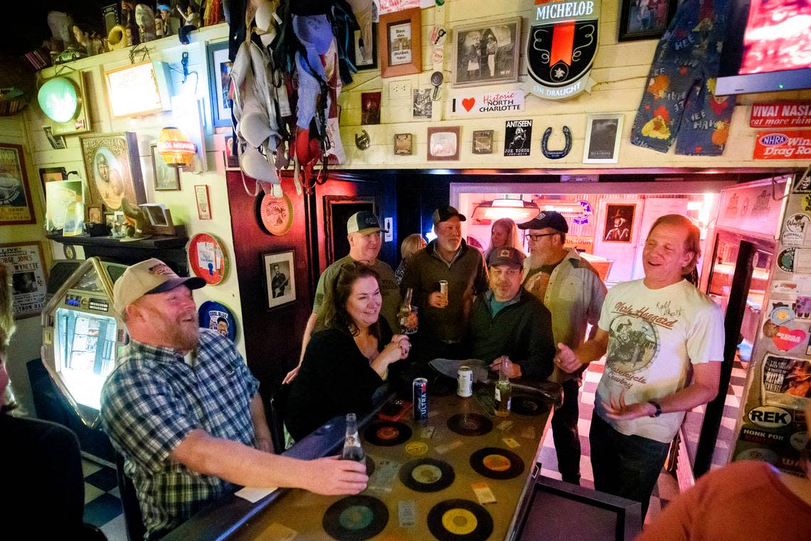 Regulars and newcomers crack jokes while sitting at the bar at the Thirsty Beaver Saloon in Charlotte, N.C., Wednesday, Feb. 23, 2022.