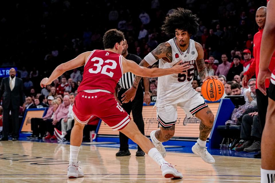 Louisville guard Skyy Clark (55) drives to the basket against Indiana guard Trey Galloway (32) during the second half an NCAA college basketball game in the Empire Classic tournament in New York, Monday, Nov. 20, 2023.