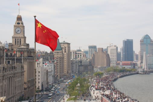 Chinese flag in foreground with The Bund in Shanghai in the background