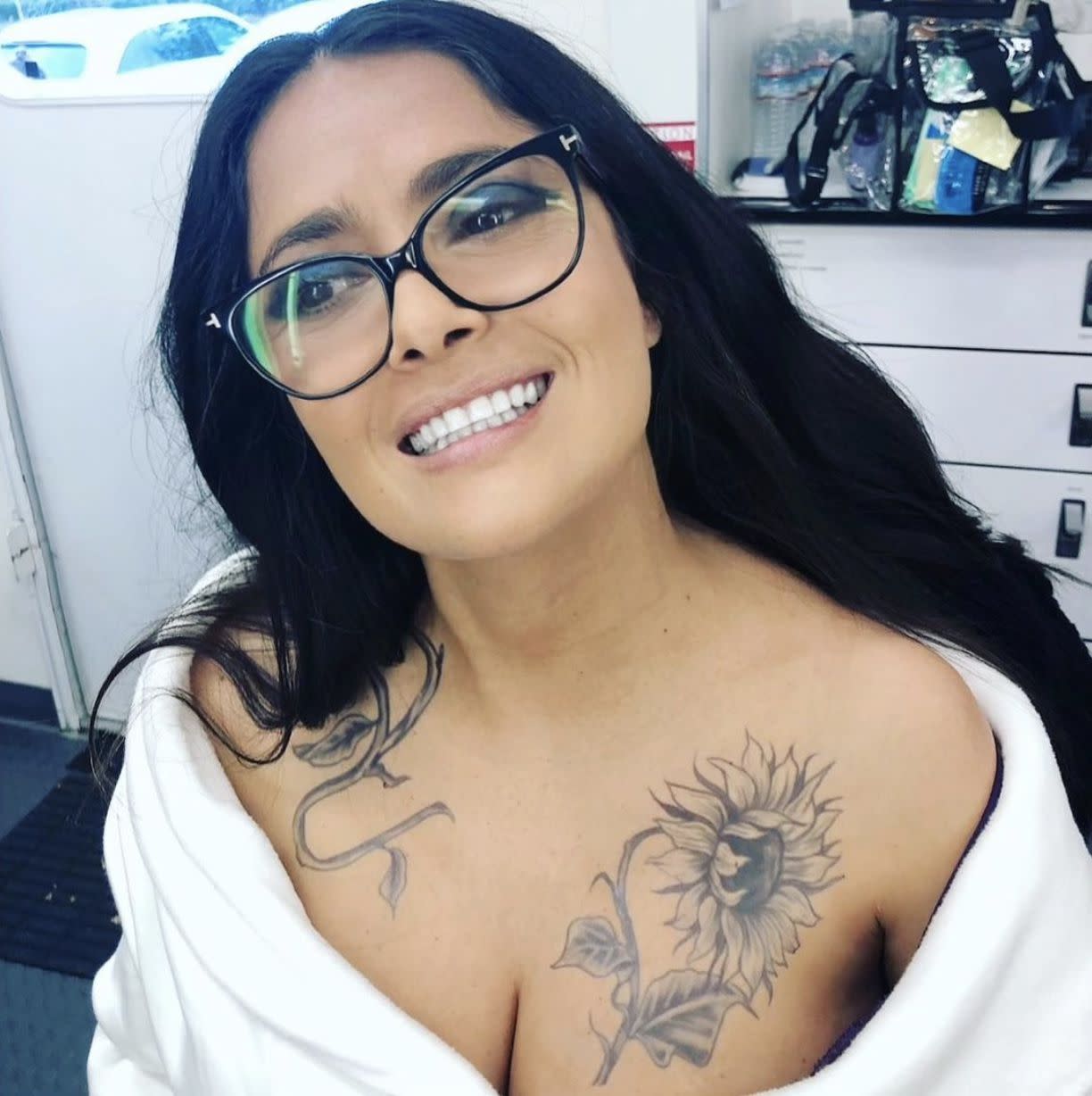 Salma Hayek is all smiles while sitting in the hair and makeup chair while on set of "Bliss." "in the middle of a #makeup #hair and #tattoo test for “Bliss”. Coming out tomorrow on @amazonprimevideo world wide"