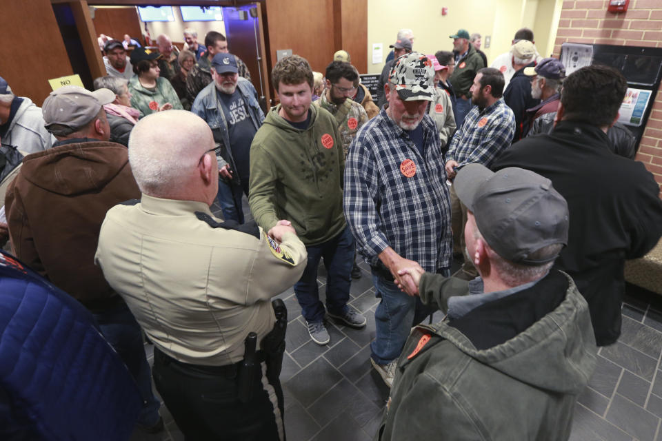 Spectators file out of a packed Buckingham County Board of Supervisors meeting after the board unanimously voted to pass a Second Amendment Sanctuary City resolution in Buckingham , Va., Monday, Dec. 9, 2019. More than two dozen counties in Virginia have voted to declare themselves “Second Amendment Sanctuaries” and are vowing to resist any attempts to tighten restrictions on guns. (AP Photo/Steve Helber)