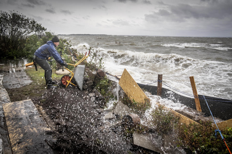 Morten Falkenby Skytte works at his summer house at Sandersvig Strand southern Jutland, Denmark, following heavy storms Friday Oct. 20 2023. (Mads Claus Rasmussen/Ritzau Scanpix via AP)