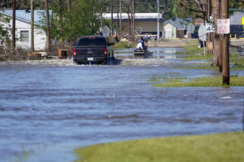 A truck drive through floodwaters in a neighborhood in Lake Charles, La., Saturday, Oct. 10, 2020, after Hurricane Delta moved through on Friday. (AP Photo/Gerald Herbert)