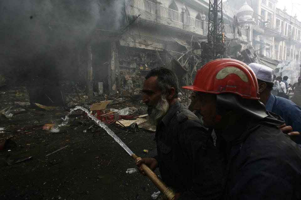 Firefighters extinguish fire at site of a bomb attack in Peshawar