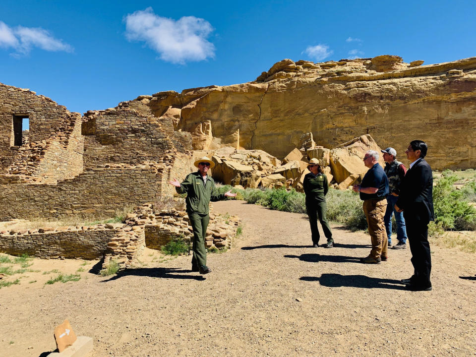 This photo provided by the Navajo Nation, Interior Secretary David Bernhardt, third from left, tours Chaco Culture National Historical Park about 95 miles northeast of Gallup, N.M., Tuesday, May 28, 2019. U.S. Sen. Martin Heinrich of New Mexico is at Bernhardt's right. Navajo Nation President Jonathan Nez is on the far right. (Jared Touchin/Navajo Nation via AP)