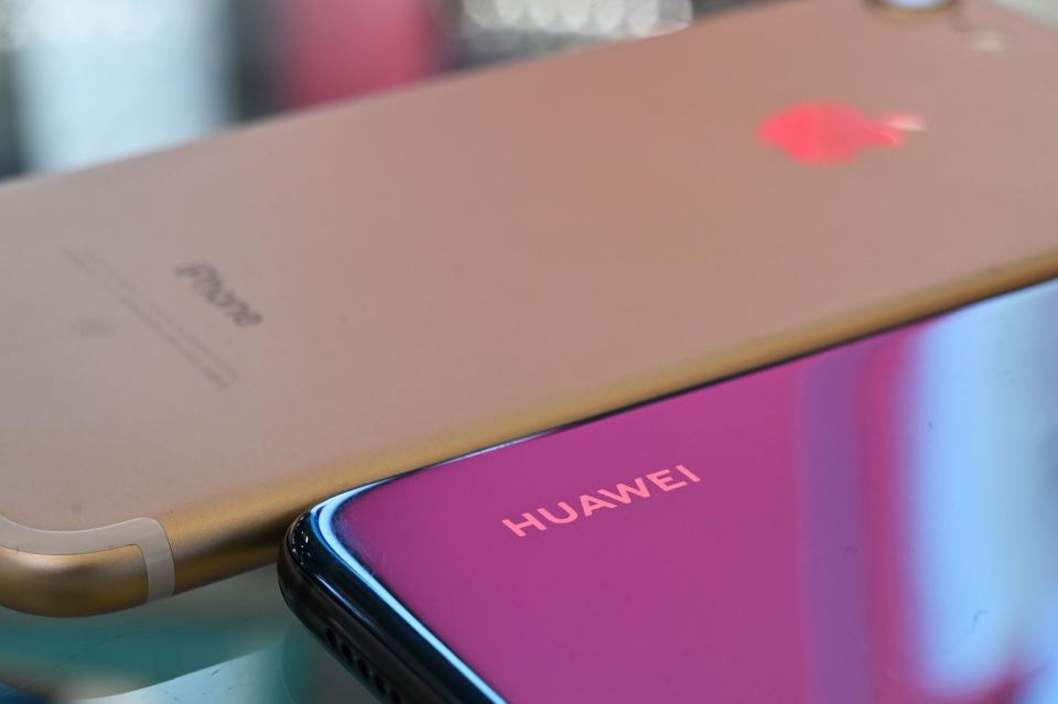 A Huawei and Apple iPhone are displayed at a store in Shanghai on May 27, 2019. Photo: HECTOR RETAMAL/AFP/Getty Images