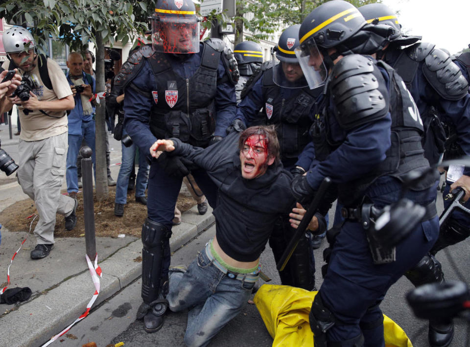 Wounded demonstrator is being evacuated by riot police