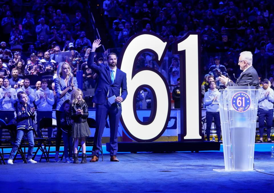 Standing beside his family, former Columbus Blue Jackets player Rick Nash waves during his No. 61 jersey retirement ceremony prior to the NHL hockey game against the Boston Bruins at Nationwide Arena in Columbus on March 5, 2022. 