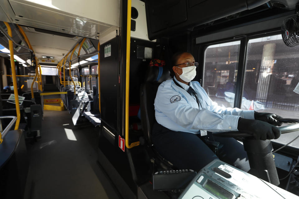 La conductora de un autobús, JaVita Brown, porta una mascarilla y guantes durante el brote de la enfermedad COVID-19 en Detroit, el miércoles 8 de abril de 2020. (AP Foto/Paul Sancya)