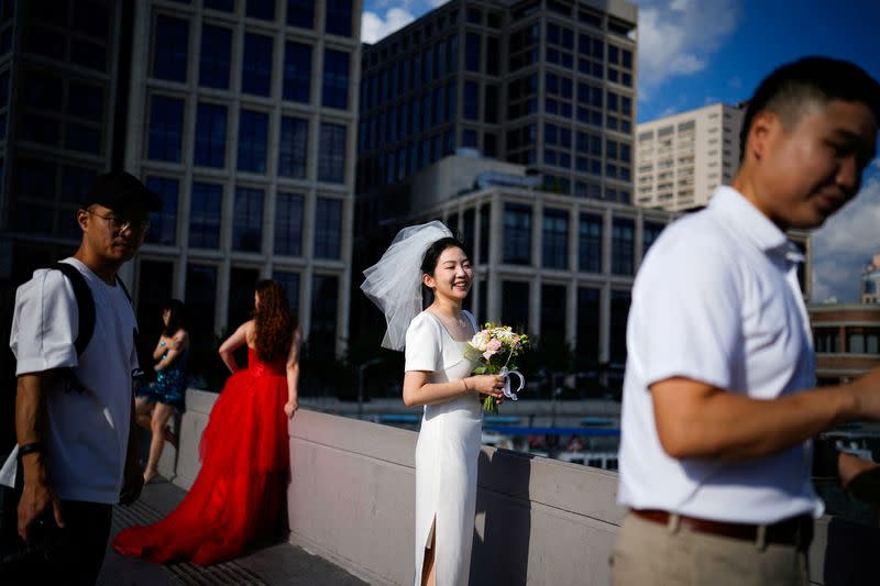 FILE PHOTO: Couples prepare to get their photo taken during a wedding photography shoot on a street, in Shanghai