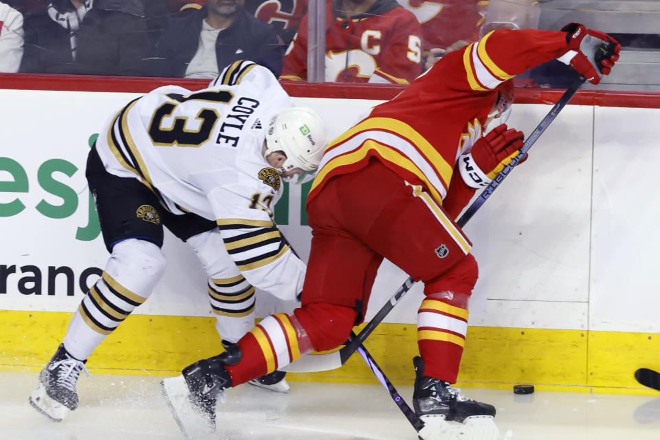 Boston Bruins' Charlie Coyle, left, and Calgary Flames' Blake Coleman work for the puck during the second period of an NHL hockey game Thursday, Feb. 22, 2024, in Calgary, Alberta. (Larry MacDougal/The Canadian Press via AP)