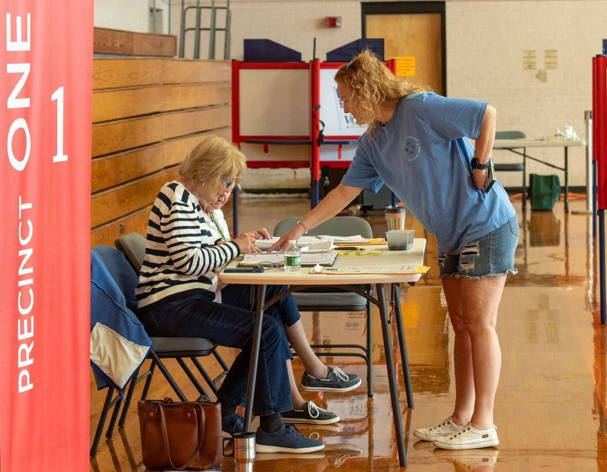 Precinct 1 voter Travis Do Rosario checks in with poll workers Carol Hansen and Mary Poirier during the Uxbridge annual town election held Tuesday at the McCloskey Complex.