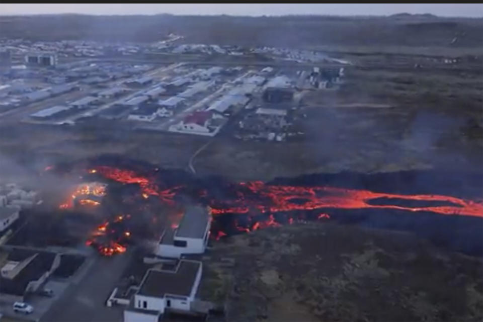 In this image made from video, volcanic activity is seen in Grindavik, Iceland, Sunday, Jan. 14, 2024. Iceland’s president says the country is battling “tremendous forces of nature” after molten lava from a volcano consumed several houses in the evacuated town of Grindavik. (Bjorn Steinbekk via AP)