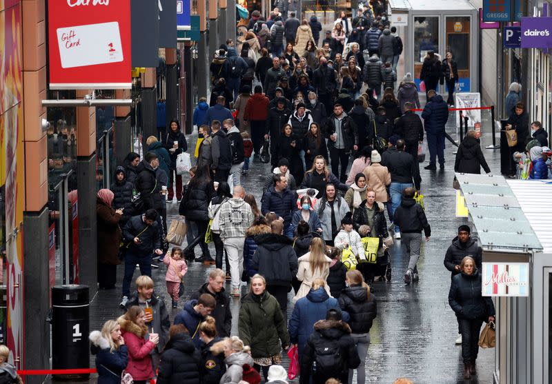 FILE PHOTO: People walk along a busy shopping street as people look for bargains in the traditional Boxing Day sales in Liverpool