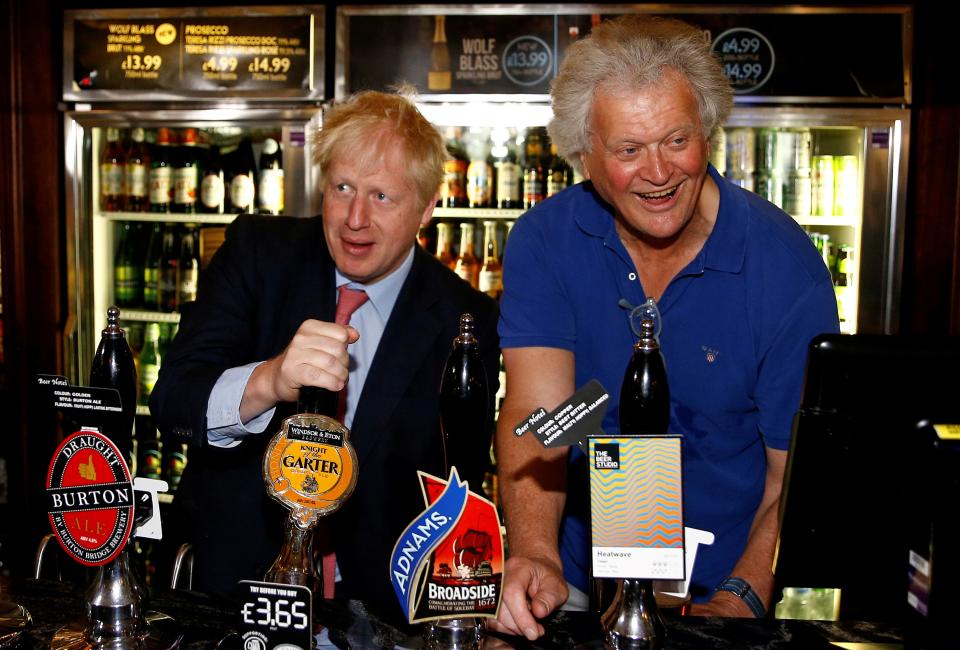 Conservative leadership contender Boris Johnson (L) pulls a pint of Windsor & Eton brewery's "Knight of the Garter" beer as he talks with JD Wetherspoon chairman Tim Martin during his visit to their Metropolitan Bar in London, on July 10, 2019. (Photo by HENRY NICHOLLS / POOL / AFP)        (Photo credit should read HENRY NICHOLLS/AFP via Getty Images)
