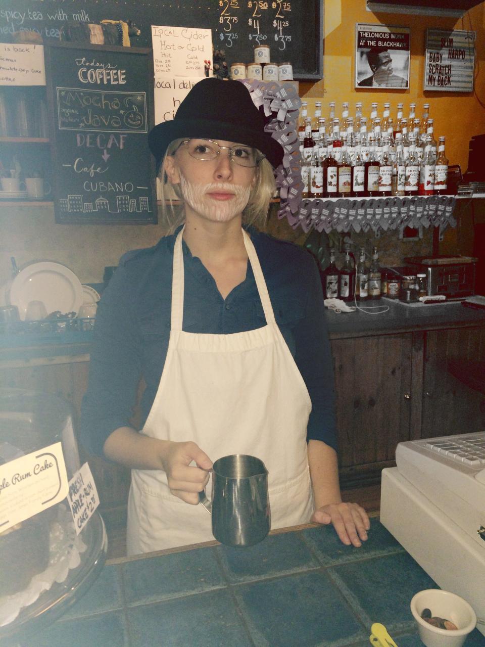 Rebecca Gleason, working a barista shift at Café Domenico, dressed as Orin Domenico for Halloween one year.