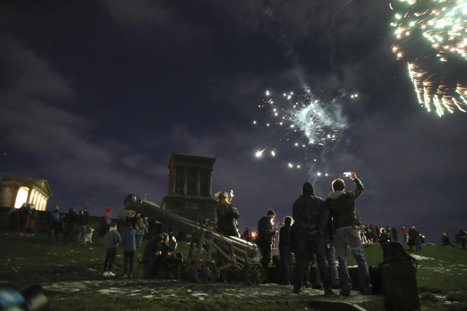 People on Calton Hill watch fireworks in Edinburgh as people are urged to avoid Hogmanay celebrations in the midst of tough coronavirus restrictions Thursday Dec. 31, 2020. (Andrew Milligan/PA via AP)