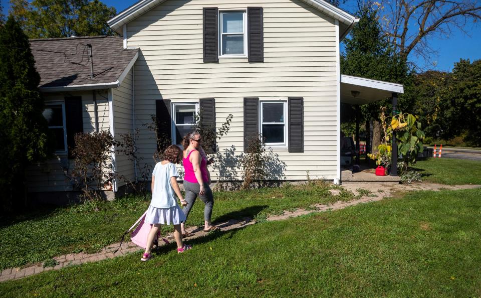 Charlie Fox, left, walks alongside her mom, Sarah Fox, outside of their home in Lapeer on Tuesday, Oct. 3, 2023. Sarah's then-5-year-old daughter, Charlie, was lost on a Lapeer Schools bus in 2019. "I wouldn't wish what happened to me and my child to happen to any other parent, especially another special needs parent," Sarah said. "Parents often ask me how I feel about them putting their child on the bus and I tell them if you could drive them yourself, do it because I really don't trust the school's bussing system."