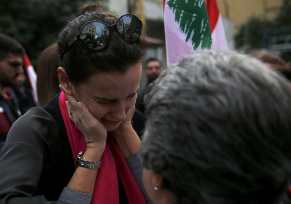 A woman cries as others comforts her, during a protest against the return of the civil war, at a former Beirut frontline between Christian district of Ain el-Rummaneh and a Muslim Shiite district of Shiyah, in Beirut, Lebanon, Wednesday, Nov. 27, 2019. Hundreds of Lebanese women marched across a former front line in the Lebanese capital carrying white roses and Lebanese flags to denounce overnight clashes between rival groups that injured dozens of people. (AP Photo/Hussein Malla)