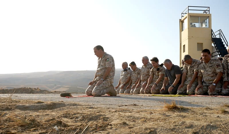 Jordan's King Abdullah and Crown Prince Hussein pray as they take part in a ceremony, in an area known as Naharayim in Hebrew and Baquora in Arabic