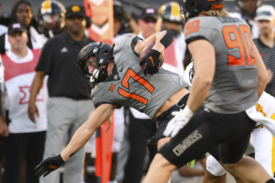 Oklahoma State fullback Braden Cassity (90) watches as wide receiver John Paul Richardson (17) reaches for a first down during the first quarter of an NCAA college football game against Arkansas-Pine Bluff, Saturday, Sept. 17, 2022, in Stillwater, Okla. (AP Photo/Brody Schmidt)