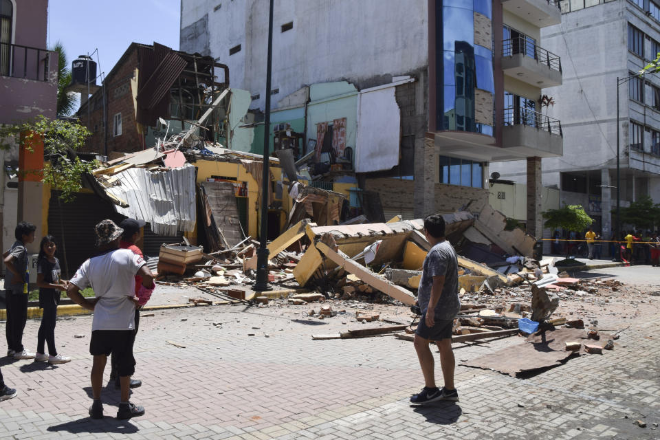 Residents look at a building that collapsed after an earthquake shook Machala, Ecuador, Saturday, March 18, 2023. The U.S. Geological Survey reported an earthquake with a magnitude of about 6.8 that was centered just off the Pacific Coast, about 50 miles (80 kilometers) south of Guayaquil. (AP Photo/Jhonny Crespo)