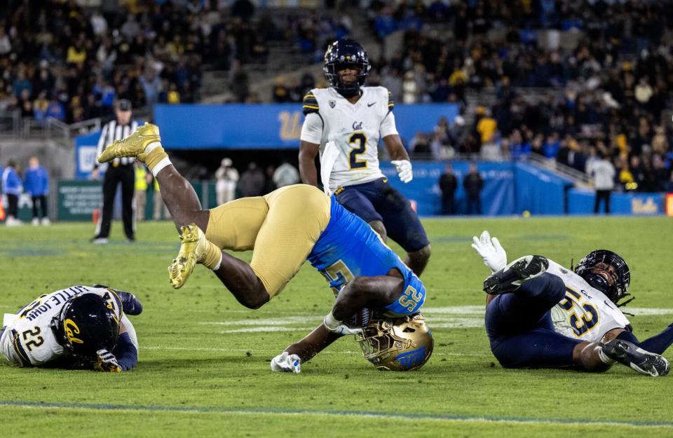 UCLA running back TJ Harden is up-ended by Cal's Kaleb Elarms-Orr (53) during the second half Saturday night