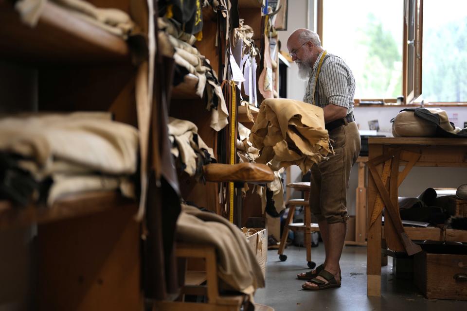 Saddler Klaus Bensmann works in his store in Bad Hindelang, Germany, Wednesday, Sept. 13, 2023. Bensmann produces tailored leather trousers and vests with hand embroidery. The leather comes from the alpine region and is tanned in Germany. For the upcoming Oktoberfest, many visitors like to wear the traditional dress. The 189th Oktoberfest, the world's biggest beer festival, runs from Sept. 16 through Oct. 3, 2023.(AP Photo/Matthias Schrader)