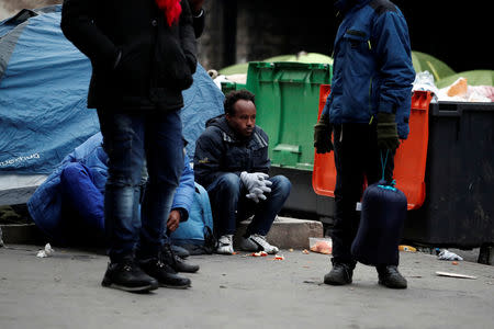 Migrants stand in line as French police evacuate hundreds of migrants living in makeshift camp set up under the Porte de la Chapelle ring bridge in Paris, France, January 29, 2019. REUTERS/Benoit Tessier