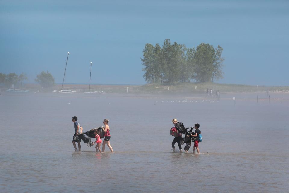 Visitors wade through flood water as they walk to Montrose Beach which has been turned into little more than a sandbar by high lake levels on June 18, 2019 in Chicago, Illinois.