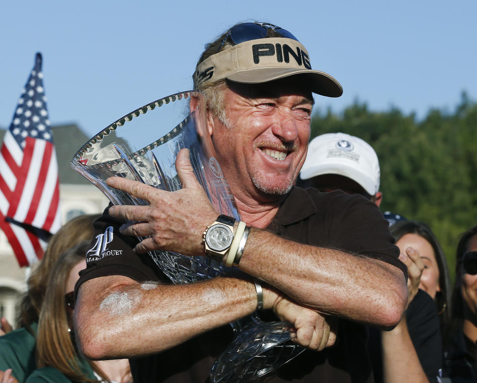 Miguel A. Jimenez hugs the trophy after wining the Greater Gwinnett Championship golf tournament of the Champions Tour, Sunday, April 20, 2014 in Duluth, Ga. (AP Photo/John Bazemore)