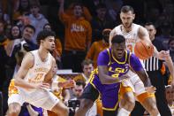 LSU forward Darius Days (4) falls as he passes the ball off as he is defended by Tennessee forward Olivier Nkamhoua (13) and forward Uros Plavsic (33) during the first half of an NCAA college basketball game Saturday, Jan. 22, 2022, in Knoxville, Tenn. (AP Photo/Wade Payne)