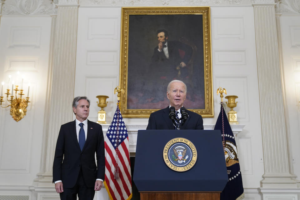 President Joe Biden speaks in the State Dining Room of the White House, Saturday, Oct. 7, 2023, in Washington, after the militant Hamas rulers of the Gaza Strip carried out an unprecedented, multi-front attack on Israel at daybreak Saturday. Thousands of rockets were fired as dozens of Hamas fighters infiltrated the heavily fortified border in several locations by air, land, and sea and catching the country off-guard on a major holiday. Secretary of State Antony Blinken listens at left. (AP Photo/Manuel Balce Ceneta)