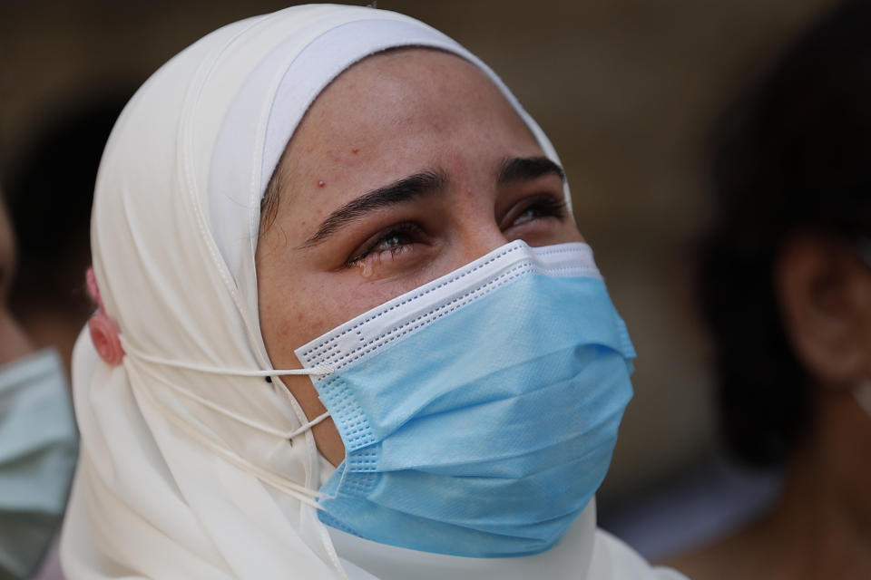 The fiancé of Ibrahim Harb, 35, a Lebanese man who was critically injured in the massive explosion at Beirut's port last year and who died on Monday nearly 14 months after the blast, mourns during his funeral procession in Beirut, Lebanon, Tuesday, Sept. 28, 2021. On Aug. 4, 2020, hundreds of tons of ammonium nitrate, a highly explosive material used in fertilizers, ignited after a massive fire at the port. The death brings to at least 215 the number of people who have been killed by the blast, according to official records. (AP Photo/Hussein Malla)