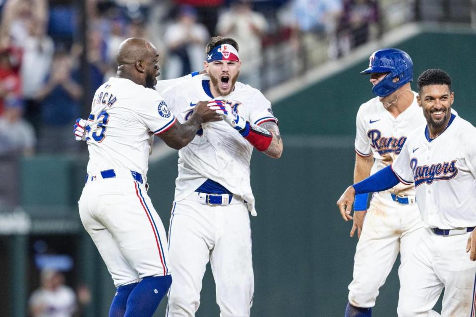 Texas Rangers catcher Jonah Heim (28) celebrates with his teammate Adolis Garcia (53) after hitting a walk off single at the bottom of the tenth inning to win their season opener against the Chicago Cubs 4-3 at Globe Life Field in Arlington on Thursday, March 28, 2024. Chris Torres/ctorres@star-telegram.com