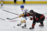 Buffalo Sabres right wing Jack Quinn, left, and Carolina Hurricanes center Jordan Staal fight for the puck during the third period of an NHL hockey game in Buffalo, N.Y., Wednesday, Feb. 1, 2023. (AP Photo/Adrian Kraus)